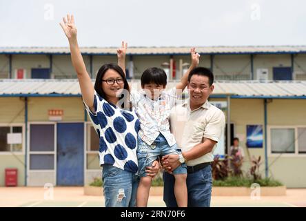 (150812) -- NANNING, 12. August 2015 -- das 7-jährige Kind Mei Mohan aus der ostchinesischen Provinz Jiangxi posiert mit seinen Eltern auf einer Baustelle in Nanning, der Hauptstadt der südchinesischen autonomen Region Guangxi Zhuang, 12. August 2015. Fast eintausend Bauarbeiter aus dem ganzen Land arbeiten auf der Baustelle der Lianqing Bridge in Nanning City, weit weg von ihren Kindern und ihrem Zuhause. Einige Kinder können nicht bis zum Frühlingsfest warten, das einzige Mal, dass ihre Eltern nach Hause zurückkehren, kamen aber während ihres Sommerurlaubs nach Nanning, um sich wiederzusehen.) (MT) CHINA-NANNING-CONSTRUCTION SITE-FAM Stockfoto