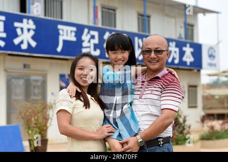 (150812) -- NANNING, 12. August 2015 -- das 8-jährige Mädchen Zhou Panni, das aus dem südwestchinesischen Chongqing kommt, posiert mit ihren Eltern auf einer Baustelle in Nanning, der Hauptstadt der südchinesischen autonomen Region Guangxi Zhuang, 12. August 2015. Fast eintausend Bauarbeiter aus dem ganzen Land arbeiten auf der Baustelle der Lianqing Bridge in Nanning City, weit weg von ihren Kindern und ihrem Zuhause. Einige Kinder können nicht bis zum Frühlingsfest warten, das einzige Mal, dass ihre Eltern nach Hause zurückkehren, kamen aber während ihres Sommerurlaubs nach Nanning, um sich wiederzusehen.) (MT) CHINA-NANNING-BAUSTELLENFAMIL Stockfoto