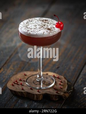 VIBRANT Red Cocktail: Ein Hauch von Eleganz auf einem Holztisch Stockfoto