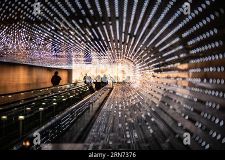 WASHINGTON DC, Vereinigte Staaten — 'Multiverse' (2008) von Leo Villareal, eine immersive Lichtskulptur-Installation mit 41.000 computerprogrammierten LEDs, beleuchtet den 200 Meter langen Concourse Walkway, der die Ost- und Westgebäude der National Gallery of Art verbindet Dieses dynamische Bildmaterial erzeugt ständig wechselnde Lichtmuster und verbindet programmierte Sequenzen mit Elementen des Zufalls. Stockfoto