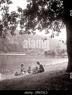 1960ER JAHRE FAMILIENPICKNICK NEBEN EINER MUTTER VATER UND SCHWESTERN AM SEE - C10374 HAR001 HARS NOSTALGIE ALTE MODE SCHWESTER 1 JUVENILE JUNGE ERWACHSENE FAMILIEN FREUDE LIFESTYLE FRAUEN VERHEIRATETE LÄNDLICHE EHEPARTNER EHEMÄNNER GESUNDHEIT NATUR KOPIEREN RAUM FREUNDSCHAFT HALBE LÄNGE DAMEN TÖCHTER MENSCHEN SZENISCH MÄNNER GESCHWISTER SCHWESTERN VÄTER B&W PARTNER AM SEE GLÜCK UND VÄTER FREIZEIT GESCHWISTER AL FRESKO NEBEN FLUCHT PICKNICK ZUSAMMENARBEIT WACHSTUM JUGENDLICHE MÜTTER ZWEISAMKEIT EHEFRAUEN JUNGER ERWACHSENER MANN JUNGER ERWACHSENER FRAU SCHWARZ-WEISS KAUKASISCHE ETHNIE HAR001 ALTMODISCH Stockfoto