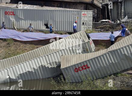 (150816) -- TIANJIN, 16. Aug. 2015 -- Menschen schließen die Explosionsstelle mit Schlamm und Plastik in der nordchinesischen Gemeinde Tianjin, 16. Aug. 2015. Insgesamt wurden 112 Leichen gefunden, und 95 Menschen, darunter 85 Feuerwehrleute, blieben vermisst, nachdem die massiven Lagerexplosionen Mittwochnacht die nordchinesische Stadt Tianjin erschütterten, sagten Beamte auf einer Pressekonferenz am Sonntagmorgen. ) (Zwx) CHINA-TIANJIN-EXPLOSION-ENCLOSURE(CN) YuexYuewei PUBLICATIONxNOTxINxCHN 150816 Tianjin Aug 16 2015 Prominente schließen die Explosionsstätte mit Schlamm und Kunststoff in der nordchinesischen Gemeinde S Tianjin Aug 1 Stockfoto