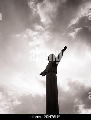 1960ER JAHRE SILHOUETTEN STATUE VON JESUS CHRISTUS IM SONNENUNTERGANG MIT SEINEN ARMEN WEIT GEÖFFNET - R20344 HAR001 HARS WEITWINKEL TRÄUME GLÜCK SEINE RELIGIÖSE STÄRKE SILHOUETTEN MUT CHRISTENTUM ÄUSSERER NIEDRIGER WINKEL MÄCHTIGE AUTORITÄT BERUFE POLITIK KONZEPT KONZEPTIONELL TREUE SYMBOLISCHE KONZEPTE ZUSAMMENARBEIT GLAUBE RETTER GEISTLICHER GLAUBE SCHWARZ-WEISS HAR001 INSPIRIERENDE JESUS CHRISTUS ALTMODISCHE DARSTELLUNG Stockfoto