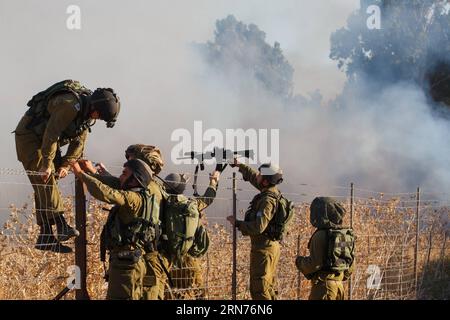 (150820) -- JERUSALEM, 20. August 2015 -- israelische Soldaten werden in der Nähe des Rauchs eines Feuers gesehen, der durch einen Raketenangriff auf die Golanhöhen nahe der libanesischen Grenze am 20. August 2015 verursacht wurde. Die israelischen Streitkräfte (IDF) feuerten Artillerie nach Syrien ab und führten Luftangriffe durch, als Reaktion auf ein Raketenstillstand, der früher in Nordisrael landete, bestätigte die IDF-Sprechereinheit in einer Erklärung. In der Erklärung der IDF wurde bestätigt, dass sie Artillerie und Luftangriffe auf Syrien abgefeuert habe, und es wurde hinzugefügt, dass sie mehrere Positionen der syrischen Armee getroffen habe und den Islamischen Dschihad mit Unterstützung des Iran und der syrischen G beschuldigt habe Stockfoto