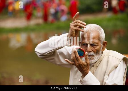 (150822) -- LALITPUR, 22. Aug. 2015 -- Ein nepalesischer Devotee zieht heiliges Ktika an, nachdem er im Godavari-Teich Ein heiliges Bad genommen hat, bevor er das Idol des Herrn Shiva während der Godavari-Puschkaram-Mela in Godavari in Lalitpur, Nepal, 22. Aug. 2015 anbetet. Godavari Pushkaram ist ein Festival, das alle 12 Jahre auf dem Fluss Godavari stattfindet. (Djj) NEPAL-LALITPUR-FESTIVAL-PUSHKARAM PratapxThapa PUBLICATIONxNOTxINxCHN 150822 Lalitpur 22. Aug 2015 ein nepalesischer Devotee nimmt DIE Heilige Tika AUF, nachdem er im Godavari-Teich ein Heiligbad genommen hat, bevor er das Idol des Herrn Shiva während der Godavari A in Godavari in Melalitpur anbeten wird Stockfoto