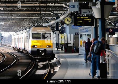 Passagiere warten am 23. August 2015 auf den ankommenden Zug am Brüsseler Bahnhof Midi in der belgischen Hauptstadt. Belgien beschloss, die Patrouillen in Zügen und Bahnhöfen zu verstärken, einen Tag nachdem der Angriff eines Kalaschnikow-Mannes auf einen Hochgeschwindigkeitszug von Amsterdam nach Paris am Samstag vereitelt worden war, sagten offizielle Quellen. Am Freitag kam es in einem Thalys-Zug zwischen Paris und Amsterdam zu einer Schießerei, bei der drei Personen verletzt wurden. Der Verdächtige ist von der Brüsseler Midi-Station an Bord gegangen, so der französische Geheimdienst. Zhou Lei) BELGIEN-ZUG-SCHIESSSTATION-SICHERHEIT?? PUBLICATIONxNOTxINxCHN Passagiere warten auf die AR Stockfoto