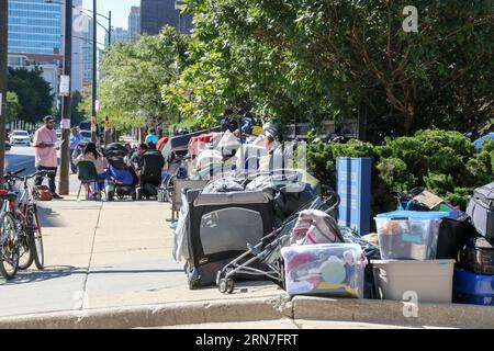 Asylbewerber und ihr hab und gut sind am 31. August 2023 außerhalb der Polizeiwache des 18. Bezirks auf der Nordseite von Chicago stationiert. Die Protokolle besagen, dass diejenigen, die sich in der Station aufhalten, in die Toiletten gehen dürfen, um die Toiletten zu benutzen. aber sonst müssen wir von 8 bis 20 Uhr draußen bleiben über 13 sind seit dem letzten Sommer 000 Asylbewerber in Chicago angekommen, und die Nachfrage nach Hilfe hat ein bereits überlastetes städtisches Schutzsystem belastet. (Foto: Alexandra Buxbaum/SIPA USA) Credit: SIPA USA/Alamy Live News Stockfoto