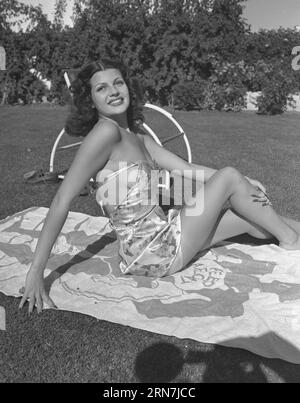 Um 1939, Hollywood, Kalifornien, USA: Amerikanische Schauspielerin RITA HAYWORTH sitzt auf einem Strandtuch. Margarita Carmen Hayworth (* 17. Oktober 1918 bis 14. Mai 1987) war eine US-amerikanische Schauspielerin, Tänzerin und Produzentin. In den 1940er Jahren erlangte sie Berühmtheit als eine der Top-Stars der Ära und trat in 61 Filmen über 37 Jahre auf. (Credit Image: © Frank Worth/ZUMA Press Wire) NUR REDAKTIONELLE VERWENDUNG! Nicht für kommerzielle ZWECKE! Stockfoto