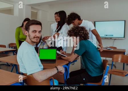 Eine Gruppe von Geschäftskollegen tauscht Wissen und Erkenntnisse aus, während sie Laptops im Büro nutzen, um kollaboratives Lernen effektiv zu präsentieren Stockfoto