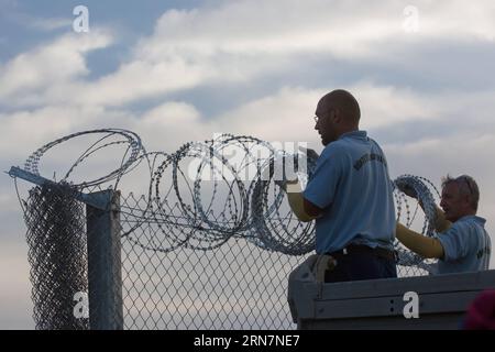 ROSZKE, 14. September 2015 - ungarische Gefängniswärter beenden die letzten Meter des Zauns an der Grenze zu Serbien, in der Nähe von Roszke, Ungarn, 14. September 2015. Die ungarischen Behörden rollten einen rasierverdrahteten Eisenbahnwagen auf das offene Gleis, das am Montag den letzten offenen Punkt an der Ungarisch-serbischen Grenze in Roszke markierte. UNGARN-ROSZKE-MIGRATION-BORDER CLOSING AttilaxVolgyi PUBLICATIONxNOTxINxCHN Roszke 14. September 2015 ungarische Gefängniswachen beenden die Last wenige METER des Zauns AN der Grenze zu Serbien bei Roszke Ungarn 14. September 2015 ungarische Behörden rollten einen Razor Wired Railraod-Wagen auf die Th Stockfoto