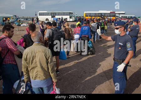ROSZKE, 14. September 2015 - ungarische Polizeibeamte wachen, als illegale Migranten am 14. September 2015 an der Grenze zu Serbien in der Nähe von Roszke in Ungarn in Busse steigen. Die ungarischen Behörden rollten einen rasierverdrahteten Eisenbahnwagen auf das offene Gleis, das am Montag den letzten offenen Punkt an der Ungarisch-serbischen Grenze in Roszke markierte. UNGARN-ROSZKE-MIGRATION-BORDER CLOSING AttilaxVolgyi PUBLICATIONxNOTxINxCHN Roszke 14. September 2015 ungarische Polizeibeamte wachen, wenn illegale Migranten AM 14. September 201 AN der Grenze zu Serbien in der Nähe von Roszke Ungarn in Busse steigen Stockfoto