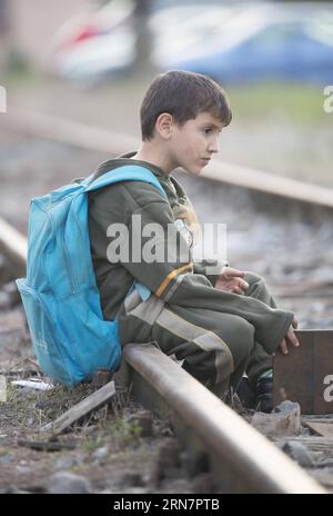 (150917) -- DUGO SELO, 17. September 2015 -- Ein Junge sitzt auf der Eisenbahn, während Flüchtlinge am Bahnhof in Dugo Selo, östlich von Zagreb, Hauptstadt von Kroatien, am 17. September 2015 auf Busse warten. Kroatien würde keinen freien Korridor zur Europäischen Union öffnen, wie einige befürchteten, sagte der kroatische Innenminister Ranko Ostojic am Mittwochabend. ) (zw) KROATIEN-DUGO SELO-FLÜCHTLINGE MisoxLisanin PUBLICATIONxNOTxINxCHN Dugo Selo 17. September 2015 ein Junge sitzt auf der Bahn, während Flüchtlinge auf Busse AM Bahnhof in Dugo Selo östlich von Zagreb Hauptstadt von Kroatien warten 17. September 2015 Kroatien würde keinen freien Korridor öffnen Stockfoto