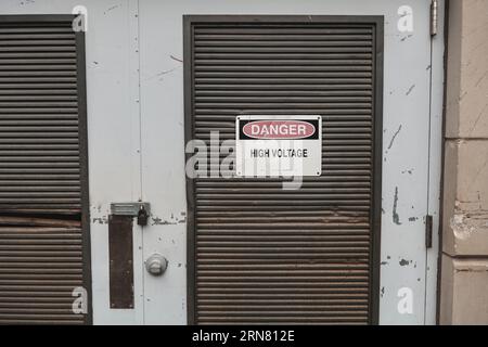 Trafotür aus Metall mit Hochspannungsschild. Stockfoto