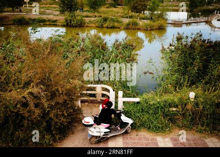 (150930) -- KASHGAR, 30. September 2015 -- Ein Paar beobachtet die Landschaft im Donghu Park in Kashgar, Nordwestchinas Autonome Region Xinjiang Uygur, 25. September 2015. Kashgar, die westlichste Stadt Chinas, war jahrhundertelang das Zentrum der uygurischen Zivilisation, ein Ort, an dem Menschen zusammenkamen, um islamisches Lernen zu handeln und zu verbreiten, auf den Karawanenrouten von Europa und Persien nach China. ) (lfj) CHINA-XINJIANG-KASHGAR-ALTSTADT (CN) ZhangxCheng PUBLICATIONxNOTxINxCHN Kashgar September 30 2015 ein PAAR Sehen Sie sich die Landschaft IM Donghu Park in Kashgar Nordwest China S Xinjiang Uygur Autonomous Region September 25 2015 Kashgar an Stockfoto