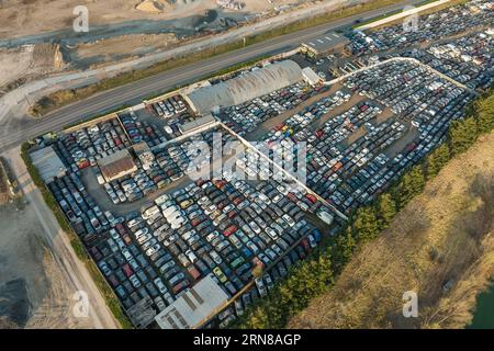 Luftaufnahme des großen Parkplatzes von Schrottplatz mit Reihen von weggeworfenen gebrochenen Autos. Recycling von Altfahrzeugen Stockfoto