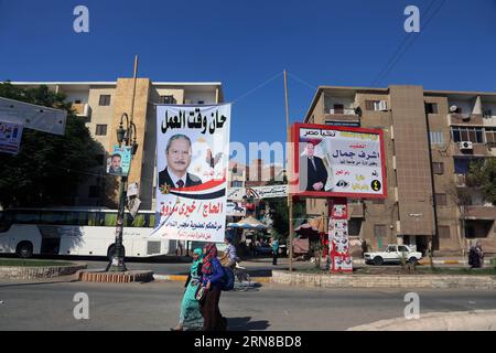(151015) -- MINYA, 15. Oktober 2015 -- Ägyptische Frauen laufen auf Banner von Kandidaten für die anstehenden Parlamentswahlen im Stadtzentrum von El-Minya, Ägypten, am 15. Oktober 2015. Die lang erwarteten Parlamentswahlen in Ägypten werden in zwei Phasen durchgeführt, die sich auf die 27 Provinzen des Landes erstrecken. Die erste Phase, die 14 Provinzen umfasst, findet am 18. Und 19. Oktober statt, die zweite Phase, die die übrigen 13 Provinzen am 22. Und 23. November umfasst. ) ÄGYPTEN-MINYA-PARLAMENTSWAHL AhmedxGomaa PUBLICATIONxNOTxINxCHN Minya OKT 15 2015 Ägyptische Frauen laufen von Bewerbern für die bevorstehende parlamentarische ELECTIO Stockfoto