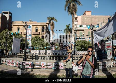 (151015) -- MINYA, 15. Oktober 2015 -- Ägypter gehen am Palastplatz vorbei, voller Plakate von Kandidaten für die anstehenden Parlamentswahlen im Stadtzentrum von El-Minya, Ägypten, am 15. Oktober 2015. Die lang erwarteten Parlamentswahlen in Ägypten werden in zwei Phasen durchgeführt, die sich auf die 27 Provinzen des Landes erstrecken. Die erste Phase, die 14 Provinzen umfasst, findet am 18. Und 19. Oktober statt, die zweite Phase, die die übrigen 13 Provinzen am 22. Und 23. November umfasst. ) ÄGYPTEN-MINYA-PARLAMENT-WAHL PanxChaoyue PUBLICATIONxNOTxINxCHN Minya OCT 15 2015 Ägypter gehen am Palastplatz vorbei voller Plakate von Candida Stockfoto