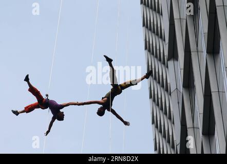 PEKING, 2015 -- Tänzer der Bandaloop-Tanztruppe der Vereinigten Staaten führen das Himmelsballett in der Nähe eines Wolkenkratzers in Shanghai, Ostchina, 14. Oktober 2015 auf. Die Vorstellung war eine Probe für das 17. Shanghai International Arts Festival, das vom 16. Oktober bis 16. November dauern wird. ) WÖCHENTLICHE AUSWAHL VON XINHUA-FOTO RenxLong PUBLICATIONxNOTxINxCHN Peking 2015 Tänzer der Banda Loop Dance Troupe der Vereinigten Staaten führen Sky Ballet in der Nähe eines Wolkenkratzers in Shanghai Ostchina OCT 14 2015 die Performance Was für eine Probe für das 17. Shanghai International Arts Festival, das von OCT geladen wird Stockfoto