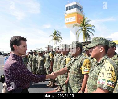 Das Bild der mexikanischen Präsidentschaft zeigt den mexikanischen Präsidenten Enrique Pena Nieto (L), der Soldaten während seines Besuchs in der Gemeinde begrüßt, die vom Durchzug der Hurricanne Patricia aus Armeria, Bundesstaat Colima, Mexiko, am 24. Oktober 2015 betroffen war. In einer Erklärung teilte Pena Nieto mit, dass es keine erheblichen Schäden gebe, da die Bevölkerung den Warnungen und Empfehlungen der Zivilschutzbehörden Folge geleistet habe und dass sie die Warnung vor dem Hurrikan rechtzeitig verbreite. Mexiko-Präsidentschaft) (da) (fnc) MEXIKO-COLIMA-POLITICS-PENA NIETO e MEXICO SxPRESIDENCY PUBLICATIONxNOTxINxCHN Image prov Stockfoto