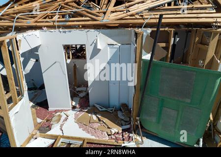 Der Wind zerstörte das Hausdach und die Wände mit fehlenden Asphaltschindeln nach dem Hurrikan Ian in Florida. Abriss von Gebäuden nach Naturkatastrophen Stockfoto