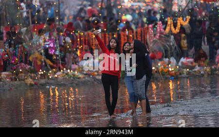 (151117) -- KATHMANDU, 17. November 2015 -- Devotees nehmen Selfies, nachdem sie Gebete an die untergehende Sonne während des Chhath-Festivals gehalten haben, das den Sonnengott am Bagmati-Fluss in Kathmandu, Nepal, am 17. November 2015 ehrt. Während des Chhath Festivals tauchen Hindus, jung und alt aus allen Gesellschaftsschichten, in Teiche oder Flüsse ein, um ein heiliges Bad zu nehmen, um der Sonne für das Geschenk des Lebens zu danken. Das Festival wird an vier aufeinanderfolgenden Tagen gefeiert. ) NEPAL-KATHMANDU-CHHATH FESTIVAL SunilxSharma PUBLICATIONxNOTxINxCHN Kathmandu 17. November 2015 Gläubige nehmen Selfies, nachdem sie der untergehenden Sonne während des C Gebete angeboten haben Stockfoto