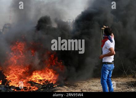 (151120) -- GAZA, 20. November 2015 -- Ein palästinensischer Demonstrant verwendet eine Schleuder, um Steine auf israelische Truppen zu schleudern, während der Zusammenstöße in der Nähe der Grenze zwischen Israel und dem zentralen Gazastreifen, 20. November 2015. Eine Welle der Spannungen zwischen Palästinensern und Israelis, die Anfang Oktober begann, hat sich zu gewaltsamen Konfrontationen in den palästinensischen Gebieten verschlechtert. Nach Angaben des palästinensischen gesundheitsministeriums wurden 89 Palästinenser getötet und mehr als 3.000 verwundet, während israelische Medien sagen, dass 14 Israelis bei Messerstechen und Schießereien getötet wurden. ) MIDEAST-GAZA-KONFLIKTE YasserxQudih PUBLICATIONxNOTxINxCHN Stockfoto