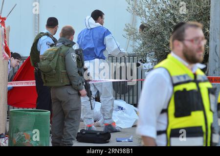 (151123) -- JERUSALEM, 23. November 2015 -- Angehörige israelischer Sicherheitskräfte und Polizeibeamter stehen neben der überdeckten Leiche eines getöteten Israelis am Ort eines Messerangriffs auf eine Tankstelle auf der Route 443, der Hauptautobahn, die die jüdischen Siedlungen in der Nähe von Jerusalem und Tel Aviv verbindet, am 23. November 2015. Am Nachmittag ersticht ein Palästinenser einen israelischen Jugendlichen vor der Tankstelle, bevor er von Soldaten erschossen wurde, sagten israelische Beamte. Er erstochen und verwundete eine weitere Israelin, eine 20-jährige Soldatin, leicht, bevor die Streitkräfte auf die drohende Tänze reagierten Stockfoto