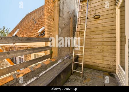 Eine Leiter an der Seite eines Hauses, die als Erweiterung für ein neues Haus im Bau verwendet wird Stockfoto