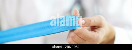 Physiotherapeutin mit blauem Klebeband in den Händen Stockfoto