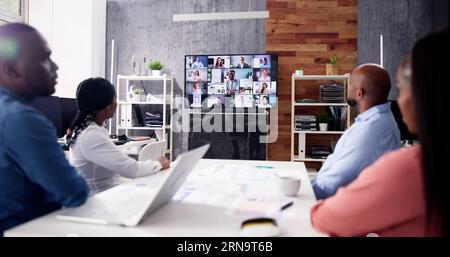 Gruppe von Geschäftsleuten in Videokonferenz mit einem anderen Geschäft Team im Büro Stockfoto