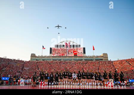 Lincoln, Nebraska, USA. 30. August 2023. Ein KC-135R Stratotanker, der dem 155th Air Tanken Wing zugewiesen wurde, fliegt über das Memorial Stadium, wobei F-16 Fighting Falcons dem 114th Fighter Wing während der Nationalhymne für das Volleyballspiel der University of Nebraska Lincoln am 30. August 2023 in Lincoln, Nebraska, zugewiesen wurden. Der Flyover fand am Volleyball Day in Nebraska statt, wo die Veranstaltung mit 92.003 Fans den Weltrekord für die Teilnahme an Sportereignissen der Frauen brach. Quelle: U.S. National Guard/ZUMA Press Wire/ZUMAPRESS.com/Alamy Live News Stockfoto