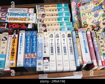 TOKIO, JAPAN - 27. August 2023: Videokassetten, DVDs und Bücher in einer Box vor einem gebrauchten Buchladen in Tokios Jimbocho-Gegend. Stockfoto