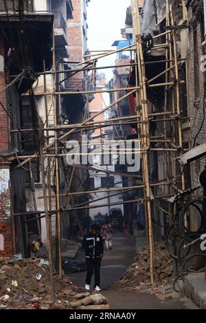 (160116) -- KATHMANDU, 16. Januar 2016 -- Ein Einheimischer geht unter Häusern, die von Holzplanken gestützt werden, in Kathmandu, Nepal, 16. Januar 2016. Am Samstag, neun Monate nach den schweren Erdbeben und Nachbeben im April 25, die Hunderttausende Menschen obdachlos und Millionen Häuser beschädigt haben, wurde in Nepal eine nationale Megakampagne für den Wiederaufbau gestartet. )(azp) NEPAL-KATHMANDU-ERDBEBEN-WIEDERAUFBAU SunilxSharma PUBLICATIONxNOTxINxCHN 160116 Kathmandu 16. Januar 2016 ein Mann aus der Gegend geht unter Häusern, die von Holzplanken unterstützt werden, in Kathmandu Nepal 16. Januar 2016 eine nationale Rekonstruktion ME Stockfoto