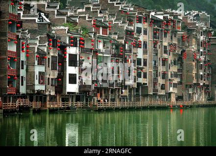 (160125) -- PEKING, 25. Januar 2016 -- Rote Laternen hängen an Gebäuden neben einem Fluss in der antiken Stadt Zhenyuan, südwestchinesische Provinz Guizhou, 26. Juli 2012. Laternen in China haben eine lange Geschichte und sind zum Synonym für die chinesische Kultur geworden. Auch heute noch werden sie von den Chinesen weltweit hergestellt und genossen. Sie wurden als Mittel des künstlerischen Ausdrucks in Bezug auf Funktionalität, Design und Dekoration verwendet. Chinesische Straßen in Städten und Städten sind während der Festivals mit roten Laternen verziert, insbesondere das chinesische Mondneujahr, das Herbstfest und das Laternenfest. (zk Stockfoto