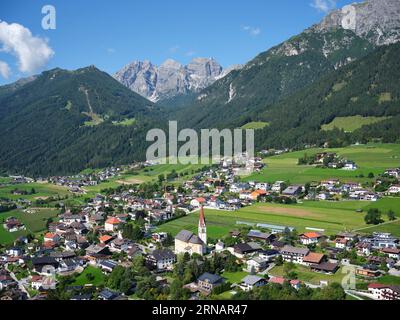 LUFTAUFNAHME. Die Kirche St. Pankratius in Telfes. In der Entfernung die Schlicker Seespitze (2804m) im Kalkkögel-Massiv. Tirol, Österreich. Stockfoto