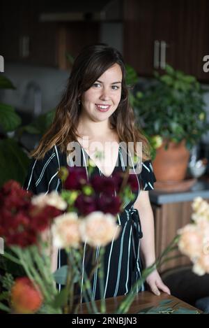 Portrait of woman surrounded by houseplants Stockfoto