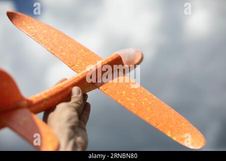 Spielzeugflugzeug in der Hand. Flugzeug zum Spielen. Leichter Gleiter. Stockfoto