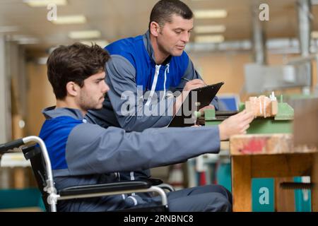 Handwerker im Rollstuhl, der in der Werkstatt arbeitet Stockfoto