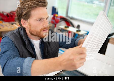 Person, die den Luftfilter einer Maschine reinigt Stockfoto