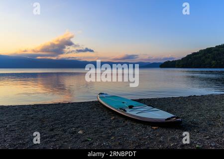 Hokkaido, Japan - 26. August 2023: Stand-up-Paddelboard am ruhigen, leeren Strand bei Sonnenuntergang Stockfoto