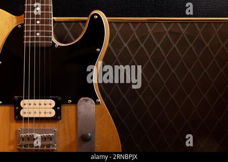 Klassische E-Gitarre, die gegen einen Verstärker lehnt Stockfoto