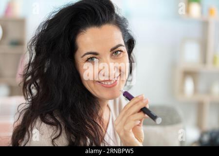 Porträt einer attraktiven Reifen Frau mit elektronischer Zigarette Stockfoto