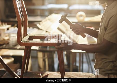 Nahaufnahme von jungen schwarzen Handwerkern, die Möbel im Sonnenlicht fixieren, Kopierraum Stockfoto