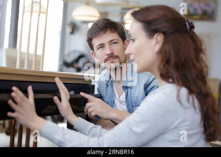 Mann und Frau bei der Wahl der Holzmöbel Stockfoto