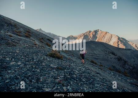 Ein Fotograf macht ein Foto beim Sonnenaufgang in den Bergen. Stockfoto