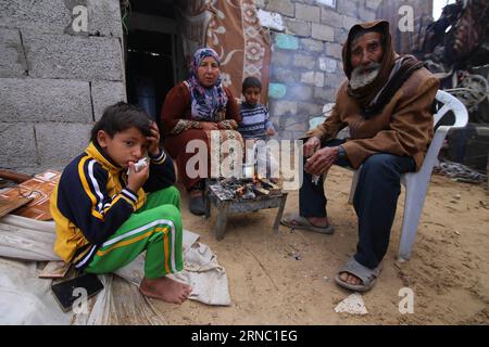 (160317) -- GAZA, 17. März 2016 -- der Palästinenser Jihan Moussa Abu Mohsen, 48, sitzt mit seinen Familienmitgliedern am 17. März 2016 in der Nähe des Feuers in ihrem Haus im südlichen Gazastreifen Khan Yunis. Jihan, der von morgens bis spät am Tag arbeitet, verkauft einen Wagen mit Ziegeln an Steinhersteller für 4 US-Dollar pro Tag. Ihre Arbeit ist die wichtigste Einkommensquelle für ihre Familie, die aus ihrem Mann und vier Kindern besteht. Jihan und ihr Sohn Ahmad stehen jeden Morgen früh auf, um Ziegel und Steine von überall zu sammeln, wo sie sie finden, ob auf Deponien, auf Straßen oder an Straßenrändern. Khaled O Stockfoto