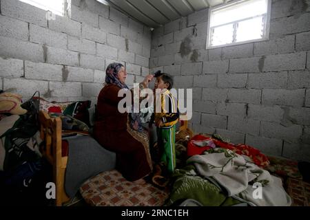 (160317) -- GAZA, 17. März 2016 -- der Palästinenser Jihan Moussa Abu Mohsen, 48, bürstet am 17. März 2016 in seinem Haus im südlichen Gazastreifen Khan Yunis die Haare seines Sohnes. Jihan, der von morgens bis spät am Tag arbeitet, verkauft einen Wagen mit Ziegeln an Steinhersteller für 4 US-Dollar pro Tag. Ihre Arbeit ist die wichtigste Einkommensquelle für ihre Familie, die aus ihrem Mann und vier Kindern besteht. Jihan und ihr Sohn Ahmad stehen jeden Morgen früh auf, um Ziegel und Steine von überall zu sammeln, wo sie sie finden, ob auf Deponien, auf Straßen oder an Straßenrändern. Khaled Omar) MIDEAST-GAZA-PO Stockfoto
