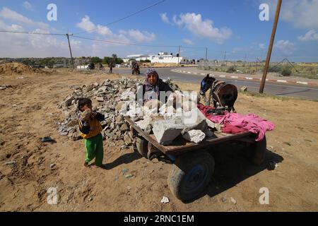 (160317) -- GAZA, 17. März 2016 -- der Palästinenser Jihan Moussa Abu Mohsen, 48, und ihr Sohn Ahmad, 10, sammeln am 17. März 2016 Steine in der Stadt Khan Yunis im südlichen Gazastreifen. Jihan, der von morgens bis spät am Tag arbeitet, verkauft einen Wagen mit Ziegeln an Steinhersteller für 4 US-Dollar pro Tag. Ihre Arbeit ist die wichtigste Einkommensquelle für ihre Familie, die aus ihrem Mann und vier Kindern besteht. Jihan und ihr Sohn Ahmad stehen jeden Morgen früh auf, um Ziegel und Steine von überall zu sammeln, wo sie sie finden, ob auf Deponien, auf Straßen oder an Straßenrändern. ) MIDEAST-GAZA-ARMUT-FRAU KHAL Stockfoto
