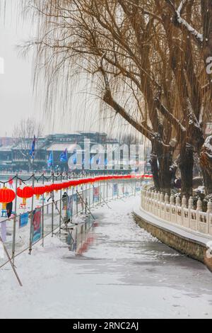 Erleben Sie den faszinierenden Anblick der alten chinesischen Architektur, die in einer unberührten weißen Schneedecke verziert ist, eine zeitlose Mischung aus Geschichte und Winterwunder. Stockfoto