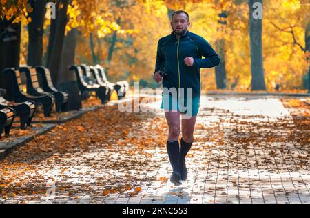 09.10.2022, Kiew, Ukraine. Man geht joggen im wunderschönen Herbststadtpark. Stockfoto
